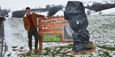 Noch ist Maskottchen Beni eingepackt, aber «Mr Osterweg» Silas Egli hat bereits die Begrüssungstafel am Eingang des Osterwegs an der Chällenstrasse in Altendorf installiert.