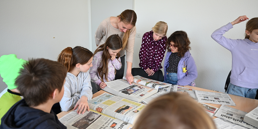 Lehrerin Carla Meier und ihre Schülerinnen und Schüler der Pull-Out-Klasse beim Durchstöbern unseres Archivs.