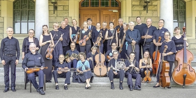 Das gut 30-köpfige Laien-Sinfonieorchester Oerlikon, also ein Ensemble mit Streichern und Bläsern. Links Dirigent Oscar Mario Echeverry – er löste 2022 den langjährigen Dirigenten Günther Stückle ab, der den Orchesterverein Oerlikon seit 2003 geleitet hatte. Das Foto entstand vor der reformierten Kirche Oerlikon an der Kreuzung Oerlikoner- und Regensbergstrasse.