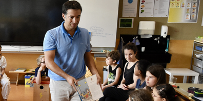 Andrea Caroni zeigt der Klasse ein Bild der Geschichte. 