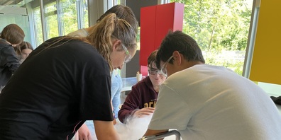 Die Schülerinnen und Schüler aus Heerbrugg stellen mit rauchendem, flüssigem Stickstoff eigenhändig Himbeereis her.