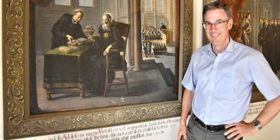 Dompfarrer Beat Grögli in der Galluskapelle neben dem Bild, das Gallus (l.) zusammen mit Kolumban, seinem Meister, zeigt.