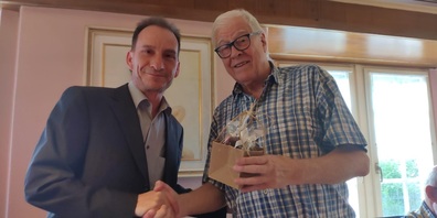 Kreispartei-Präsident Stefan Wäckerlin gratuliert der SVP Rapperswil-Jona zum Jubiläum und übergibt Präsident Hans Peter Rathgeb ein symbolisches Präsent. (Foto: André Riva)