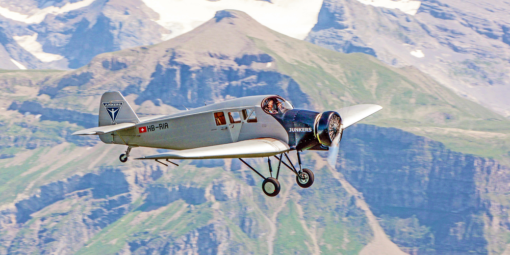 Der Co-Pilot winkt den  Zuschauern der OldtimAIR Flugparade 2022 in Stanserhorn (Schweiz) freundlich aus dem offenen Cockpit der «JUNKERS F13» zu. 