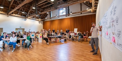 Die Tagungsgäste und Tobias Zahn vor der visuellen Darstellung der Ergebnisse.