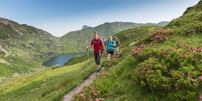 Wanderer auf dem Sardona Welterbeweg entlang des Murgsees.