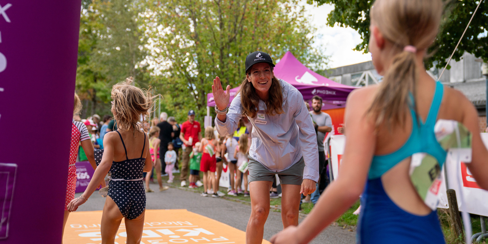 Olympiasigerin Nicola Spirig klatscht die Kids im Ziel ab.