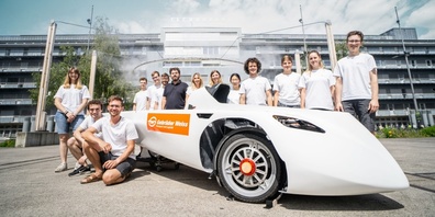 Das Solarauto mit dem Team der ETH Zürich und Frank Haas, Leiter Kommunikation (7. von links) Katharina Zimmerling, Niederlassungsleiterin Air & Sea Zürich, und Vanessa Hafner, Team Lead Digital Communications (rechts daneben, alle Gebrüder Weiss). 