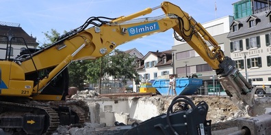 Die Eigentümer Jürg und Rico Pengler beobachten aus sicherer Distanz, wie der grosse Bagger das alte Mauerwerk fachgerecht abträgt.