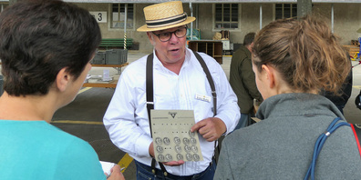 Der Chef des Museumsshops, Erwin Müller. Gerade zeigt er der Kundschaft Sternegg-Plaketten.