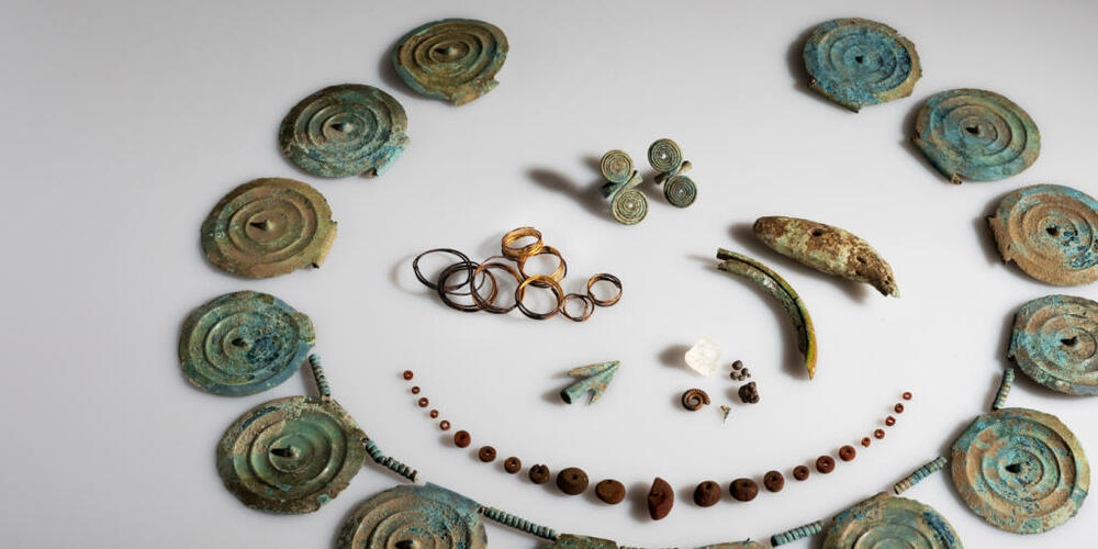 Der Fund der Archäologen umfasst ein Collier mit Stachelscheiben, eine Bernsteinkette, Fingerringe, Goldspiralen und einen Bärenzahn oder Ammoniten.