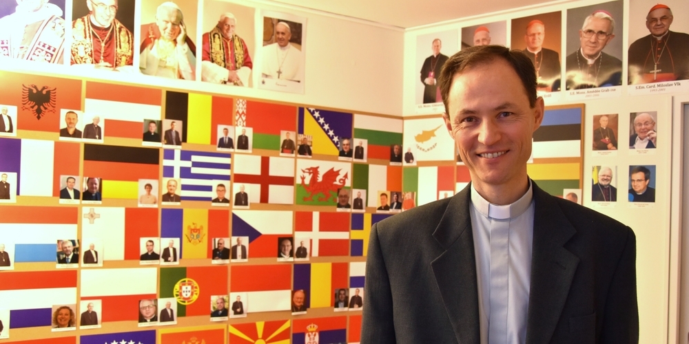 Der heutige Generalsekretär des CCEE, Martin Michalíček, vor der Wand mit Vertretern der europäischen Bischofskonferenzen. Er nennt die Umzugsgründe.