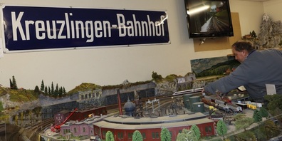 Ein Zug passiert eine Gartenlandschaft en miniature.