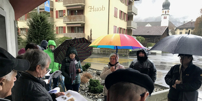 Gut beschirmt: Rund 30 Interessierte trotzen dem Regenwetter und lauschen den Worten ihres «Zeitreiseführers» Pius Good.