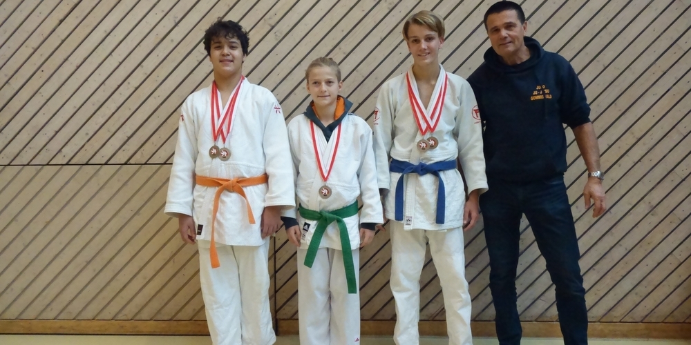 Die U15-Kämpfer freuen sich mit Trainer Romano Bonzani (r.) über die Medaillen.