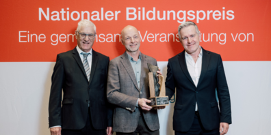 Christian Fiechter (links) und Stefan Schulthess (rechts) gratulieren Claude Merlach, Geschäftsführer von login Berufsbildung AG, zum Gewinn des Nationalen Bildungspreises. 