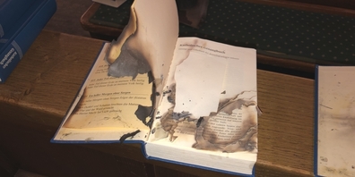 Eine unbekannte Täterschaft hat neben Kirchgesangsbüchern (Bild) auch ein Taufbuch und Opferkerzen angezündet.