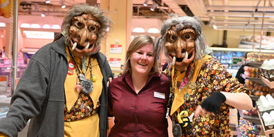 Zwei Moorhexen posieren mit einer Migros-Mitarbeiterin.