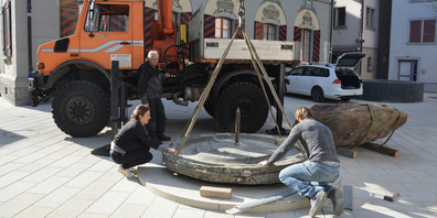 Der Chauffeur Mathe Mächler (Vorderthal), der Steinbildhauer Peter Scherrer (Siebnen) und die Künstlerin Tanja Laeri (Zürich) platzierten die tonnenschweren Steine zentimetergenau auf einem Rondell. (Bild Urs Attinger)