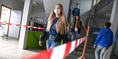 Baden-Württemberg, Baienfurt: Schüler der Achtalschule gehen zu Testzwecken eine durch Absperrband geteilte Treppe hinunter und hinauf.  Wie wird es in Ausserschwyz ablaufen? (Bild: Keystone)