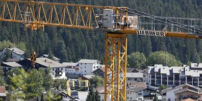 Ein Baukran über der Gemeinde Laax. Die Bautätigkeit hat in Graubünden laut einer Studie des Kantons wieder etwas Fahrt aufgenommen, ist aber immer noch zu gering für eine Entspannung auf dem knappen Wohnungsmarkt. (Archivbild)