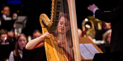 Die Harfenistin spielt im Orchester.
