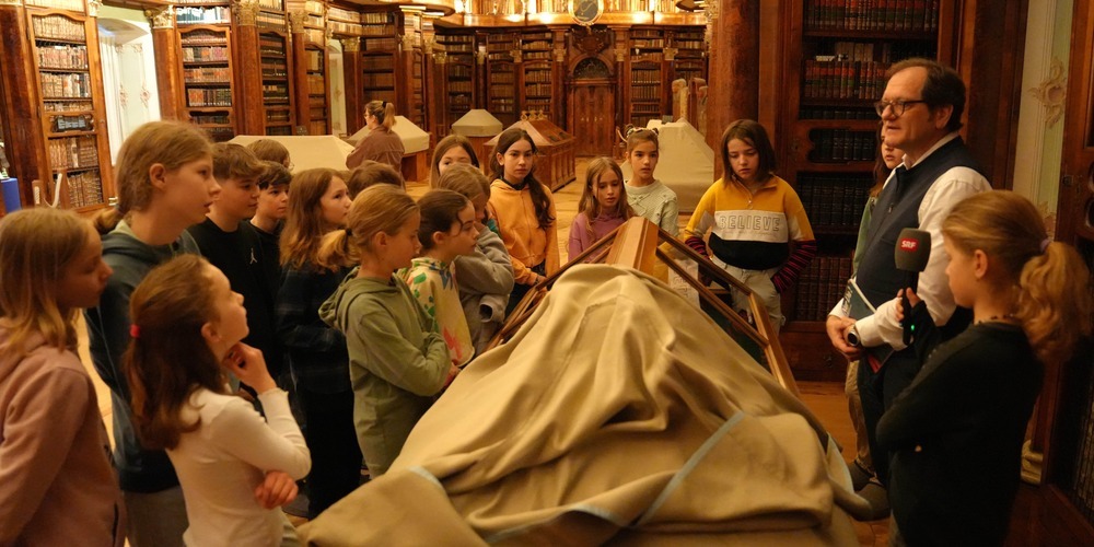 Der Stiftsbibliothekar schafft es, mit seinen Ausführungen die Kinder in den Bann zu ziehen.