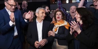 Mustafa Atici und seine Frau Cennet freuen sich mit Regierungsrat Kaspar Sutter, links, Regierungsraetin Tanja Soland, vorne rechts, und ihren Anhängern nach den ersten Zwischenresultaten
