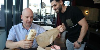  Gastgeber Julius Kartal vom Restaurant Pan Rolito in Berg zeigt einem Gast, wie er diese leckeren Teigrollen isst. 