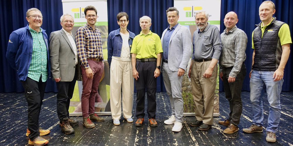 Gruppenbild mit Dame: Stefanus Bertsch (Wanderwege AR), Axel Zimmermann (Gemeinde Pfäfers), Hannes Heller (Verein Moveable),  Regierungsrätin Susanne Hartmann, SGW-Präsident Stefan Frei, Patrik Schlegel (Gemeinde Vilters-Wangs), Willi Marthy (Geehrter),  Daniel Litscher (Fachstelle für Fuss- und Veloverkehr) und SGW-Geschäftsführer Viktor Styger (von links).