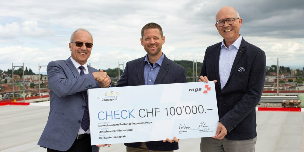 Philipp Simmen (Mitte), Leiter «Helikopter Einsatz» und Mitglied der Rega-Geschäftsleitung übergibt den Check an Arno Noger (links), Stiftungsratspräsident der Stiftung Ostschweizer Kinderspital, und Guido Bucher (rechts), Direktor und Vorsitzender der Spitalleitung des OKS.