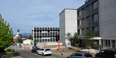 Der Zugang zu Rathaus (rechts) und Justizgebäude (mitte) als neuem Verwaltungszentrum des Bezirks Höfe erfolgt über die Rebhaldenstrasse in der Leutschen Freienbach; links ist die Kirche Freienbach zu erkennen. 