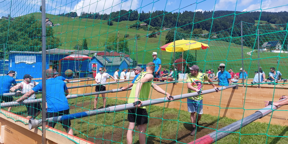 Am Bschöttirohr-Grümpi sind die Teilnehmer an Bschöttirohren befestigt und versuchen, den Ball ins gegnerische Tor zu befördern, ähnlich wie bei einem Töggelifussballspiel.