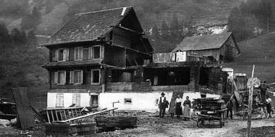 Ab Mitte Juni 1924 wurde das «Pfusti» niedergerissen (r.). Vor den Ruinen stehen Vater Franz Josef Schättin, Tochter Maria (das spätere Mueti), Mutter Elisabeth Schättin und eine Verwandte.