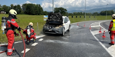 Feuerwehrangehörige beim Löschen des brennenden Personenwagens in Bilten. Der 78-jährige Lenker konnte rechtzeitig aussteigen.