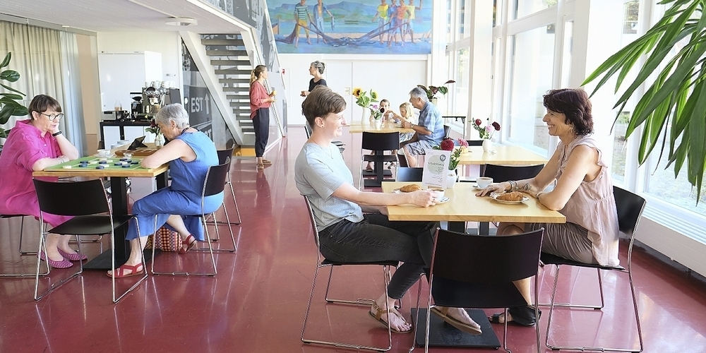 Im Foyer des Zentrums Hauriweg sind Menschen an den Tischen in Gesprächen vertieft.