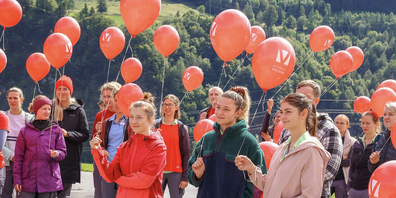 Über 50 Mitarbeitende des Rehazentrums Valens nehmen am «September Walk» teil: Symbolisch nehmen sie einen roten Luftballon mit auf den Spaziergang.
