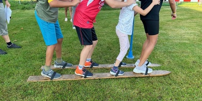 Auf Holzski als Team über die Wiese: Der Spiel- und Sporttag ist für alle Kinder der Primarschule Gossau ein grosser Spass.