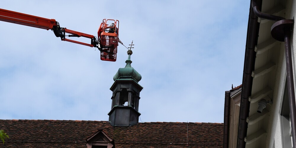 Das Dachkreuz über dem Dekanatsflügel steht etwas schräg in der Landschaft.
