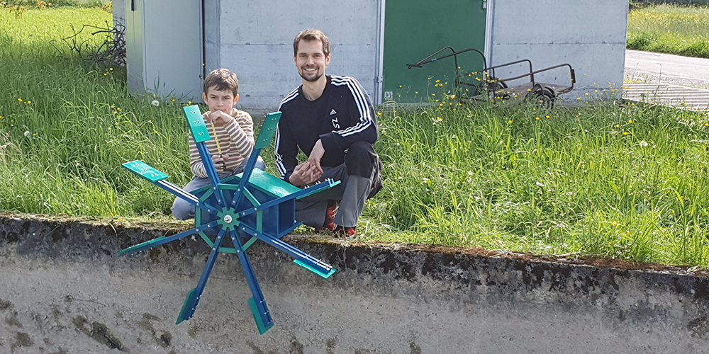 Philipp Bruhin und sein Sohn Julien vor dem Wasserrad.