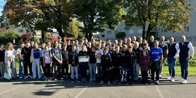 Junioren und Trainer vom HC Rheintal mit dem Check und den Sponsoren von Helvetia Versicherungen Jürg und Marc Schwarber (ganz rechts).