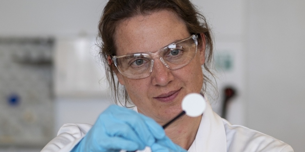 Empa-Forscherin Meike Heinz hält ein Scheibchen des Keramikelektrolyten für die Salzbatterie.
