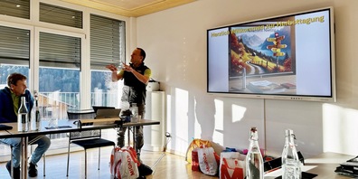 Geschäftsführer Viktor Styger begrüsst die Tagungsgäste mit einem ChatGPT Bild im Hotel Hirschen in Wildhaus, links von ihm Jürg Schaufelberger