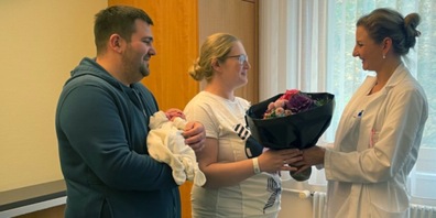 Dr. med. Martina Kreft, Leitende Ärztin Gynäkologie und Geburtshilfe, gratuliert den Eltern des kleinen Áron mit einem Blumenstrauss.
