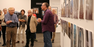 Andreas Henschel, Präsident des Fotoclubs Rapperswil-Jona, erklärt dem Kunstverein Oberer Zürichsee die verschiedenen Arbeiten.
