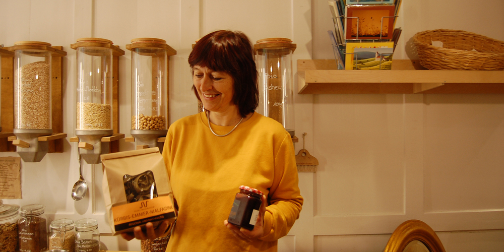 Diana Zucca ,Geschäftsinhaberin des «PeperOhni», mit Kürbis-Emmer-Malfadine in «gschiider» Verpackung in ihrer rechten und köstlicher Confi in ihrer linken Hand.