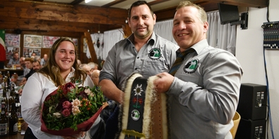 Vereinspräsident Adi Oertig (r.) und Vorstandskollegin Michelle Brunner (l.) überreichen Reto Holdener Blumen und eine zünftige Schelle.