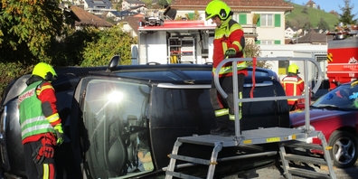 Angehörige der Feuerwehr Uznach-Schmerikon beim spektakulären Übungseinsatz an einem gekippten Unfallauto.