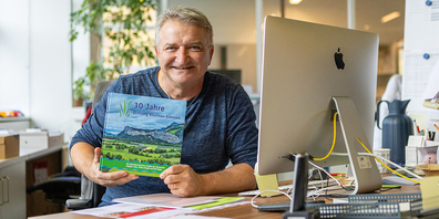 Ein Projekt wird gewürdigt: Oliver Thüring präsentiert das von ihm gestaltete Jubiläumsbuch.