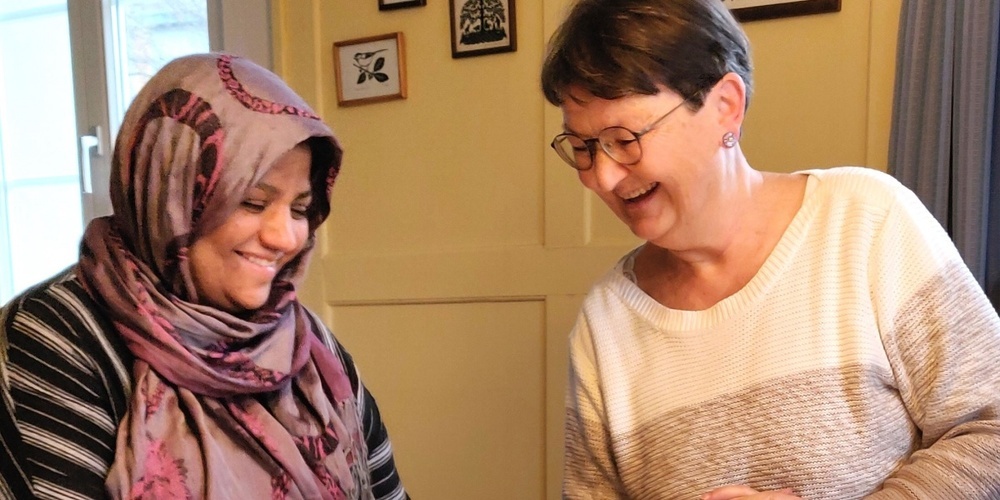 Eine pensionierte Lehrerin hilft als Freiwillige einer Teilnehmerin bei der Alphabetisierung.